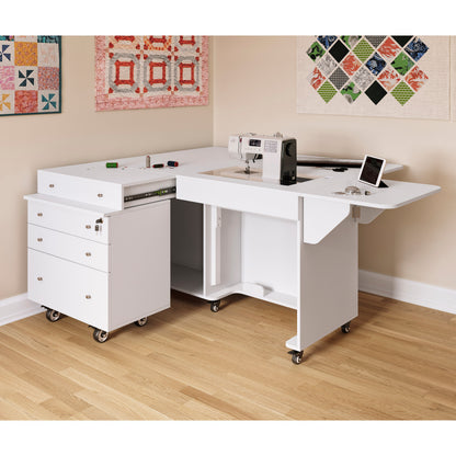 Kangaroo Sewing Table with Joey Cabinet in White — Lifestyle Sewing Room Setup with Quilted Wall Art